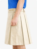 Beige pleated skirt worn by a person with a blue top on a white background