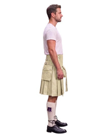 A man shown in profile wearing a beige kilt with multiple flap pockets, a white t-shirt, white knee-high socks with a purple emblem, and black leather shoes, against a plain white background.