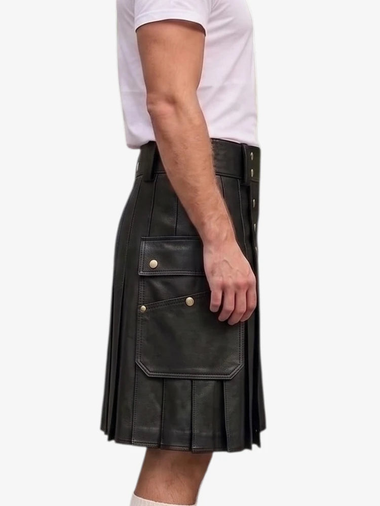 A side view of a person wearing a black leather pleated kilt with brass button details, paired with a white t-shirt, against a plain white background.