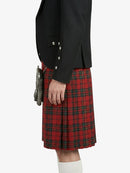 Person wearing a black jacket and red plaid kilt on a white background