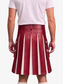 A person shown from the back wearing a pleated red leather kilt with vertical white stripes and silver-tone decorative hardware, paired with a light gray T-shirt against a plain light background.