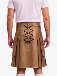 A person shown from the back wearing a tan pleated kilt with black lace-up detailing down the center and side cargo pockets, paired with a light pink t-shirt and white socks against a plain white background.