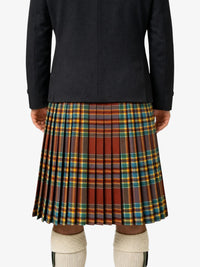 Person wearing a black jacket and plaid kilt on a white background