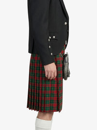 Person wearing a black jacket and red plaid kilt on a white background