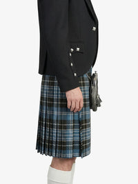 Person wearing a black blazer and blue plaid kilt on a white background