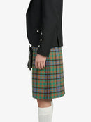 Person wearing a black blazer and green plaid kilt on a white background
