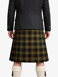 Person wearing a dark jacket and green plaid kilt on a white background
