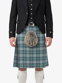 Person wearing a traditional Scottish kilt with a tartan pattern on a white background