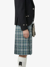 Person wearing a black jacket and plaid kilt on a white background