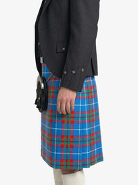 Person wearing a dark jacket and blue plaid kilt on a white background