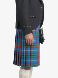 Person wearing a dark gray jacket and a blue plaid kilt on a white background