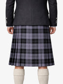 Person wearing a gray plaid kilt with a dark jacket on a white background
