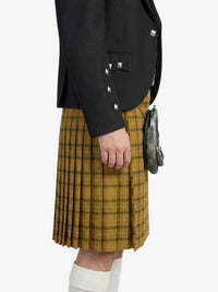 Person wearing a black jacket and yellow plaid kilt on a white background
