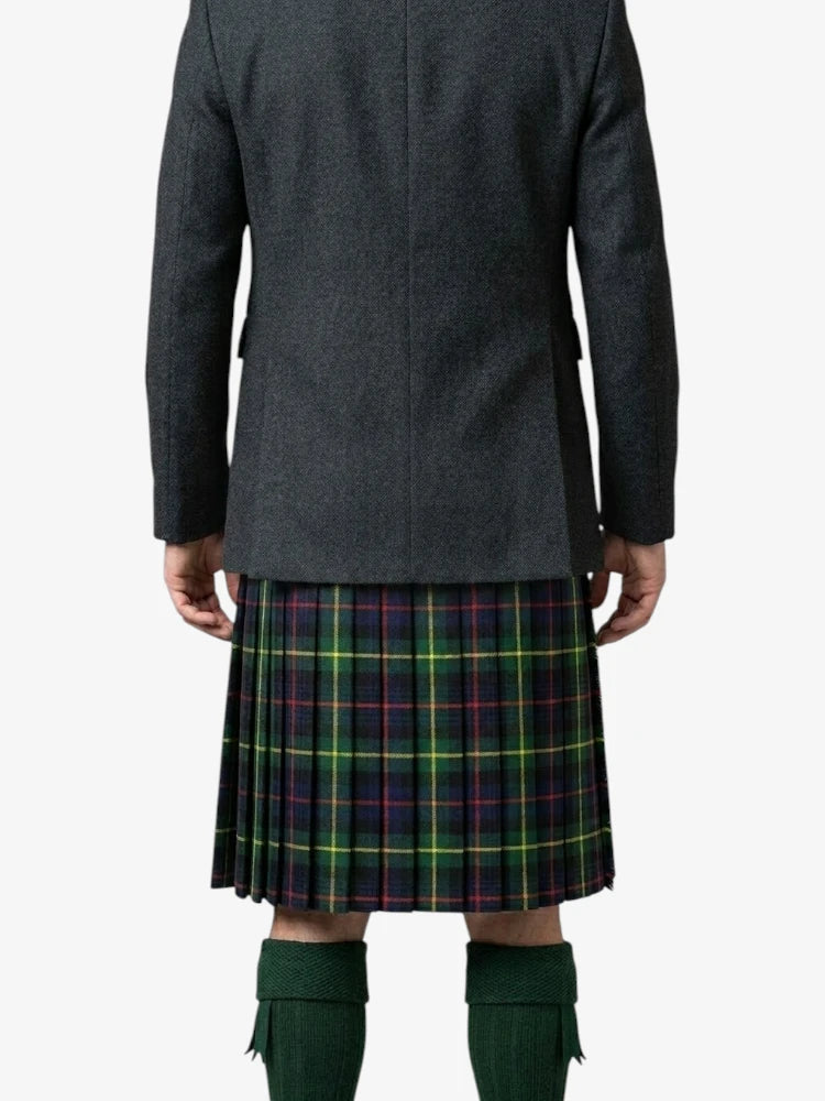 Person wearing a dark gray coat and a plaid kilt on a white background