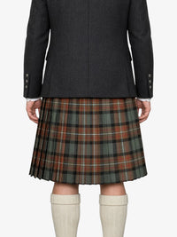 Person wearing a dark jacket and plaid kilt on a white background