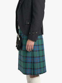 Person wearing a dark jacket and green plaid kilt on a white background