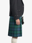 Person wearing a dark gray blazer and green plaid kilt on a white background