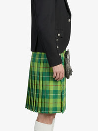 Person wearing a green plaid kilt with a black jacket on a white background