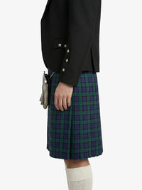 Person wearing a black blazer and green plaid kilt on a white background