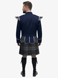 Man wearing a navy blue doublet jacket with white accents and a grey watch tartan kilt on a white background
