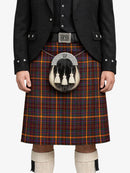 Person wearing a traditional Scottish kilt with a tartan pattern on a white background