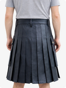 Person wearing a black pleated kilt on a white background