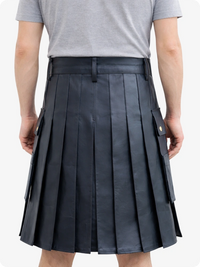 Person wearing a black pleated kilt on a white background