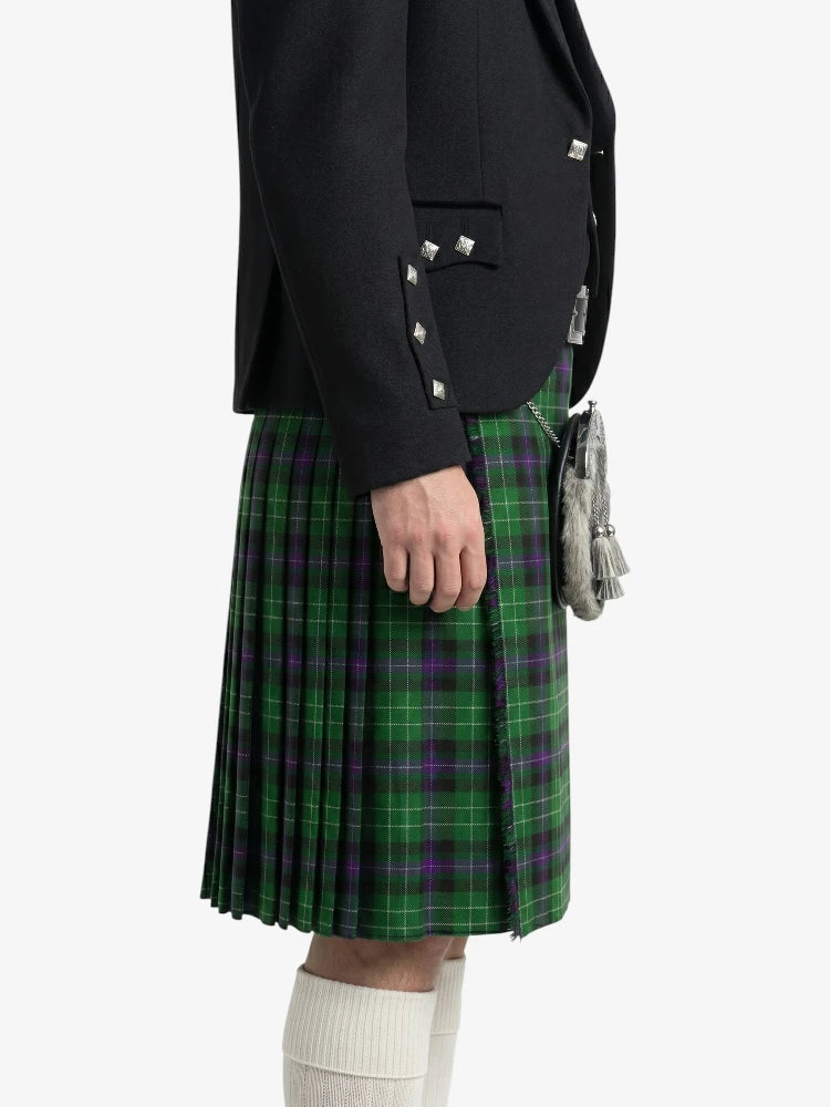 Person wearing a black jacket and green plaid kilt on a white background