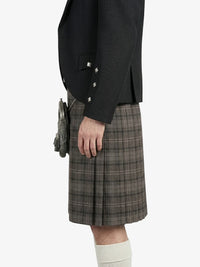 Person wearing a black jacket and plaid kilt on a white background