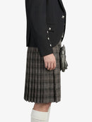 Person wearing a black jacket and plaid kilt on a white background