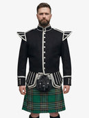 Man wearing a black doublet jacket with white trim and a irish national plaid tartan kilt on a white background