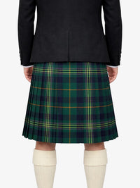 Person wearing a black jacket and green plaid kilt on a white background