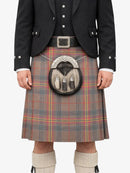 Person wearing a traditional Scottish kilt with a sporran on a white background