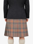 Person wearing a black jacket and plaid kilt on a white background