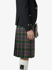 Person wearing a dark jacket and plaid kilt on a white background