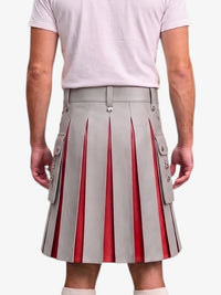 A person shown from the back wearing a light gray pleated kilt with vertical red pleated inserts and side flap pockets with metal snap details, paired with a pale pink T-shirt and white socks against a light gray studio background.