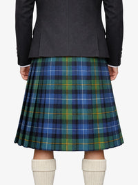 Person wearing a black jacket and plaid kilt on a white background
