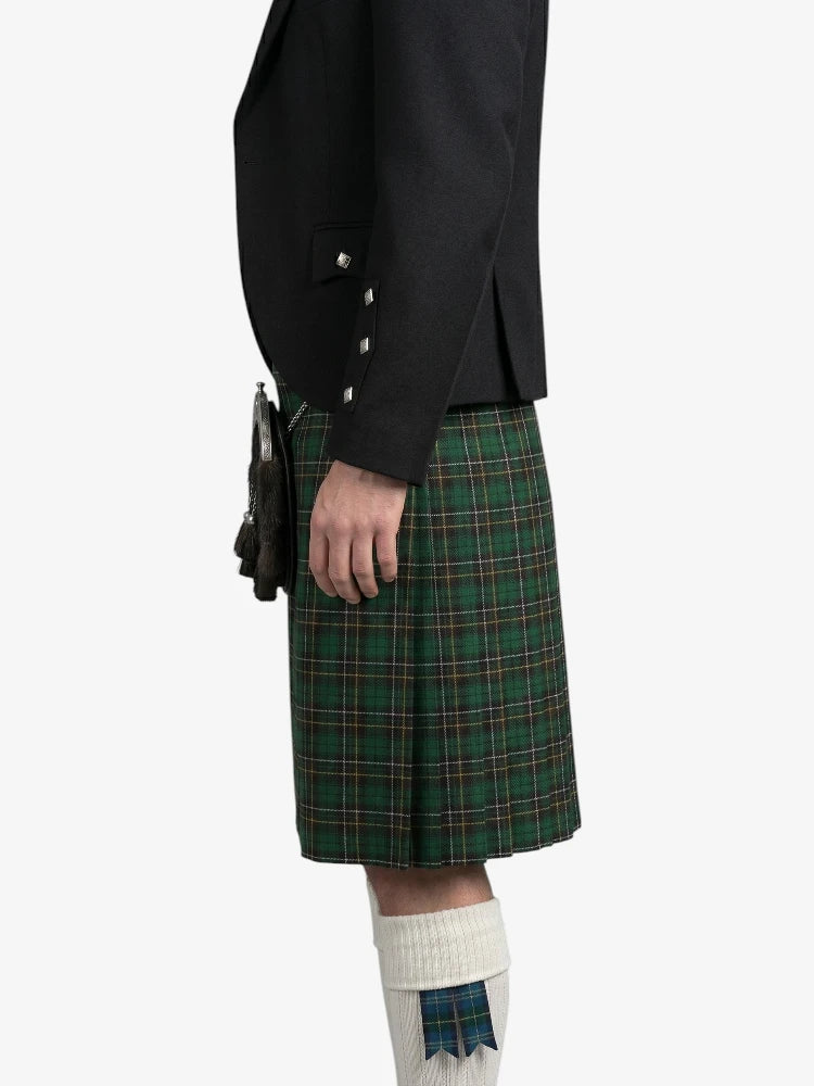 Person wearing a black jacket and green plaid kilt on a white background
