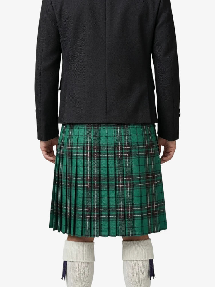 Person wearing a black jacket and green plaid kilt on a white background