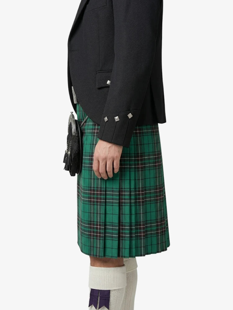 Person wearing a green plaid kilt with a black jacket on a white background