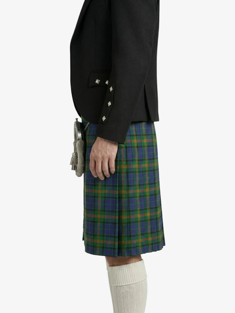 Person wearing a black jacket and blue plaid kilt on a white background