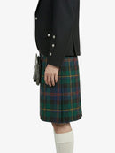 Person wearing a black jacket and green plaid kilt on a white background