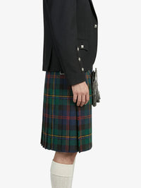 Person wearing a black jacket and green plaid kilt on a white background