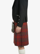 Person wearing a black jacket and red plaid kilt on a white background