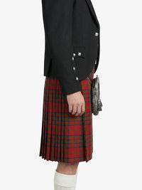 Person wearing a black jacket and red plaid kilt on a white background