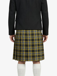 Person wearing a black blazer and plaid kilt on a white background