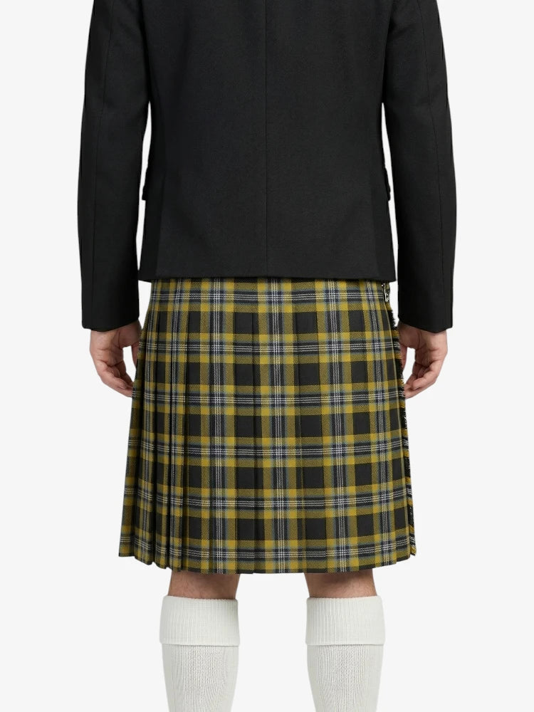 Person wearing a black blazer and plaid kilt on a white background