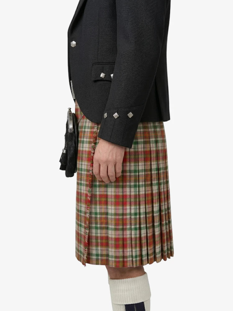 Person wearing a black jacket and plaid kilt on a white background
