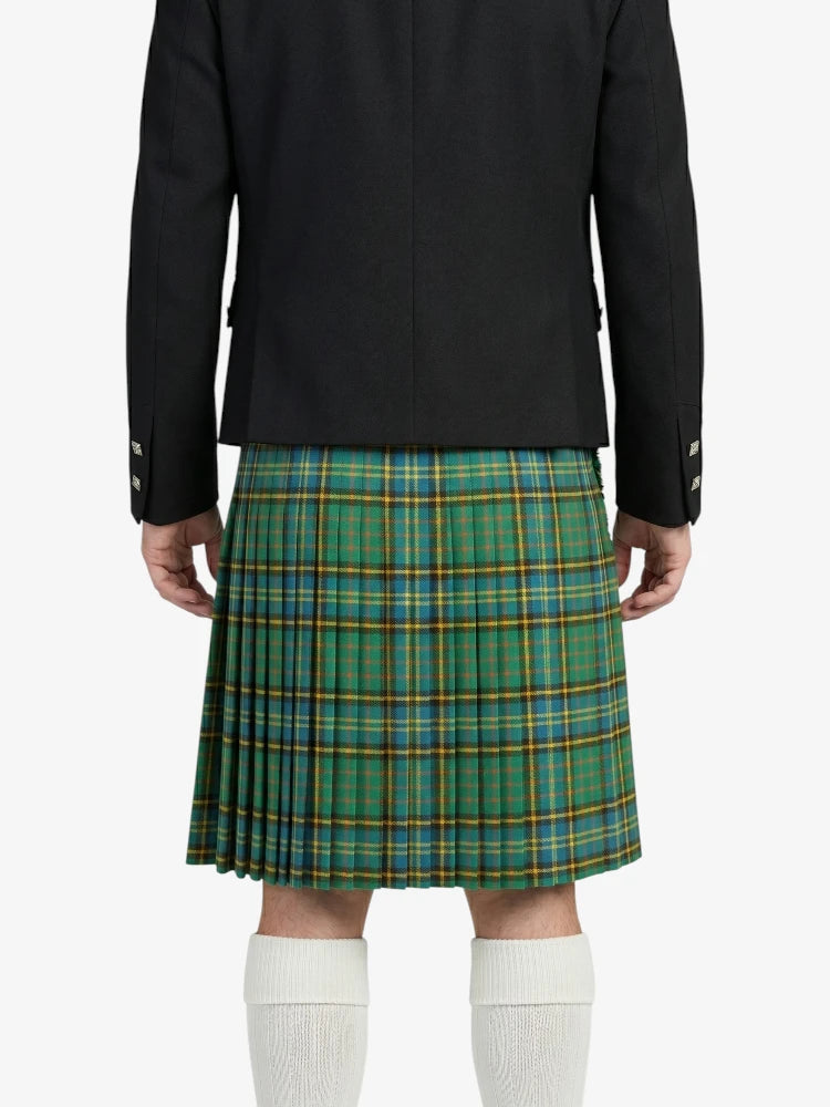 Person wearing a black jacket and green plaid kilt on a white background