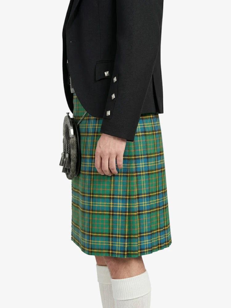 Person wearing a black jacket and green plaid kilt on a white background